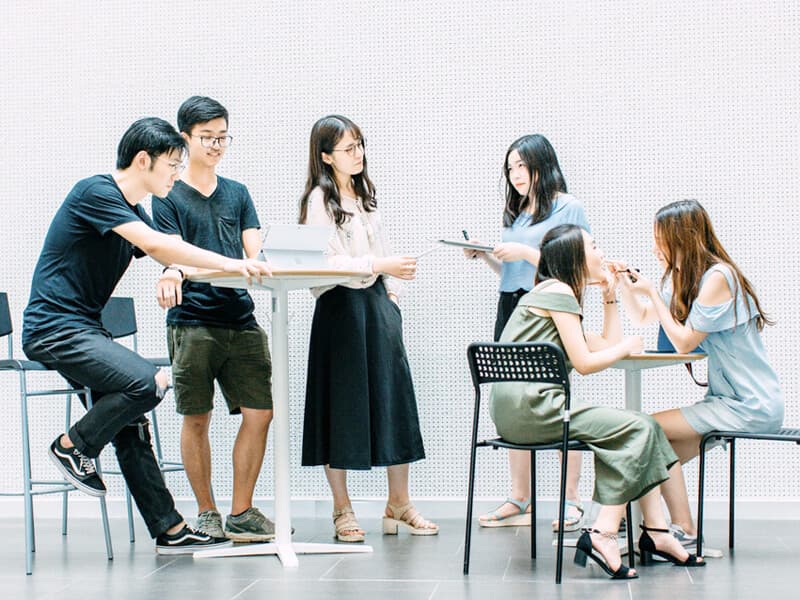 Team collaborating around a laptop